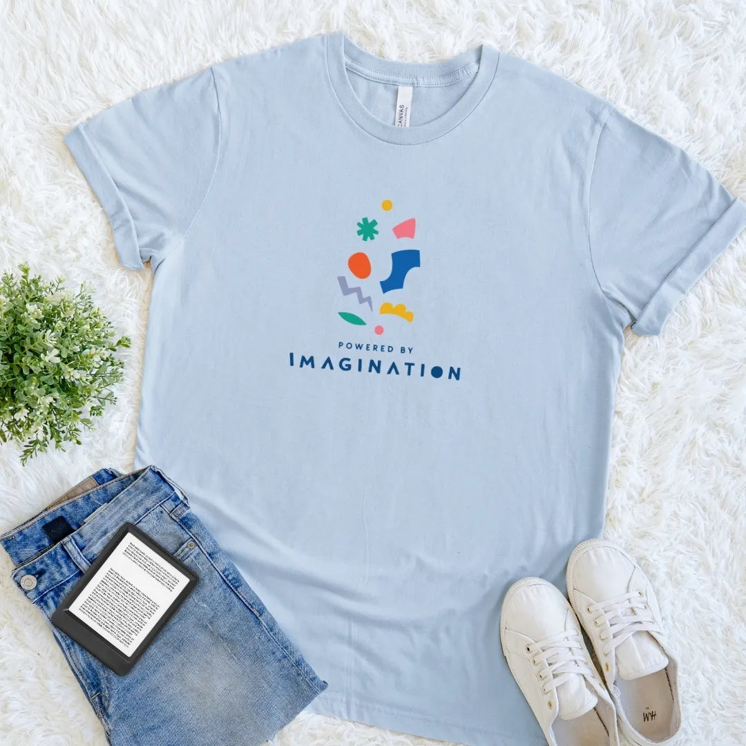 Light Blue Powered by Imagination book lover T-shirt featuring bright abstract graphics and cheerful lettering, a creative reader shirt for everyday bookish style.
