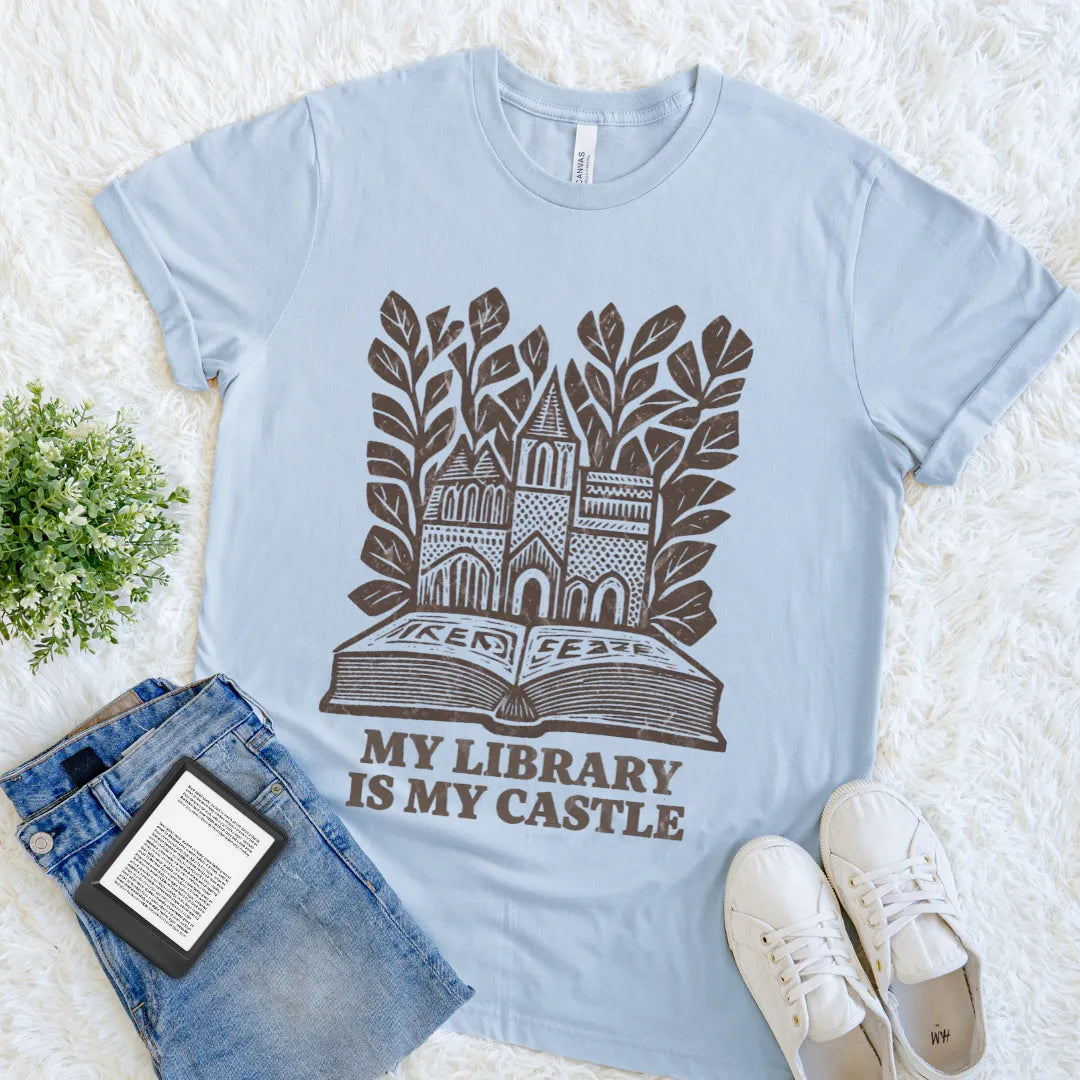 Soft cotton reader shirt with My Library Is My Castle quote and book artwork on light blue cotton