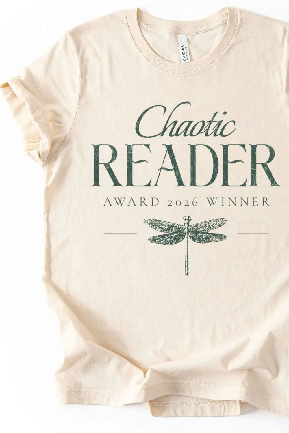 Beige bookish t-shirt with 'Chaotic Reader Award 2026 Winner' text and dragonfly graphic on a white background