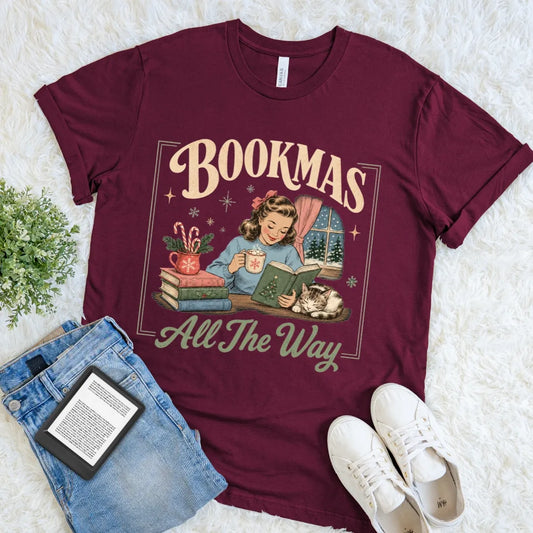 Maroon Bookmas All the Way T-shirt featuring a vintage Christmas reader illustration in cream, green, blue, and red.