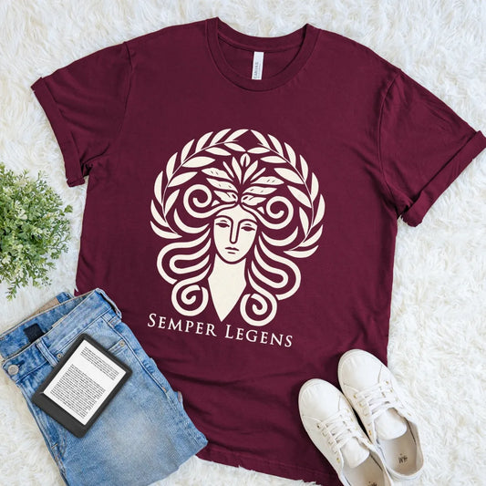Maroon Semper Legens T-shirt with a stylized woman, curling ram horns, leafy crown, and cream Latin lettering