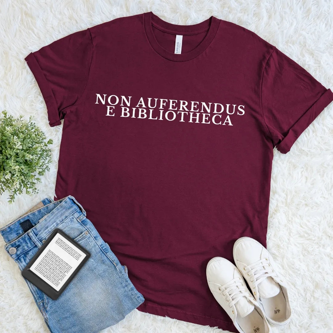 Maroon Non Auferendus E Bibliotheca library T-shirt with cream serif Latin quote typography meaning “do not remove from the library,” a dark academia literary shirt for readers, librarians, bibliophiles, and book lovers.