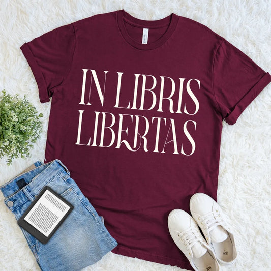 Maroon book lover T-shirt with “In Libris Libertas” Latin quote, dark academia literary graphic tee for readers, librarians, and classic literature lovers.