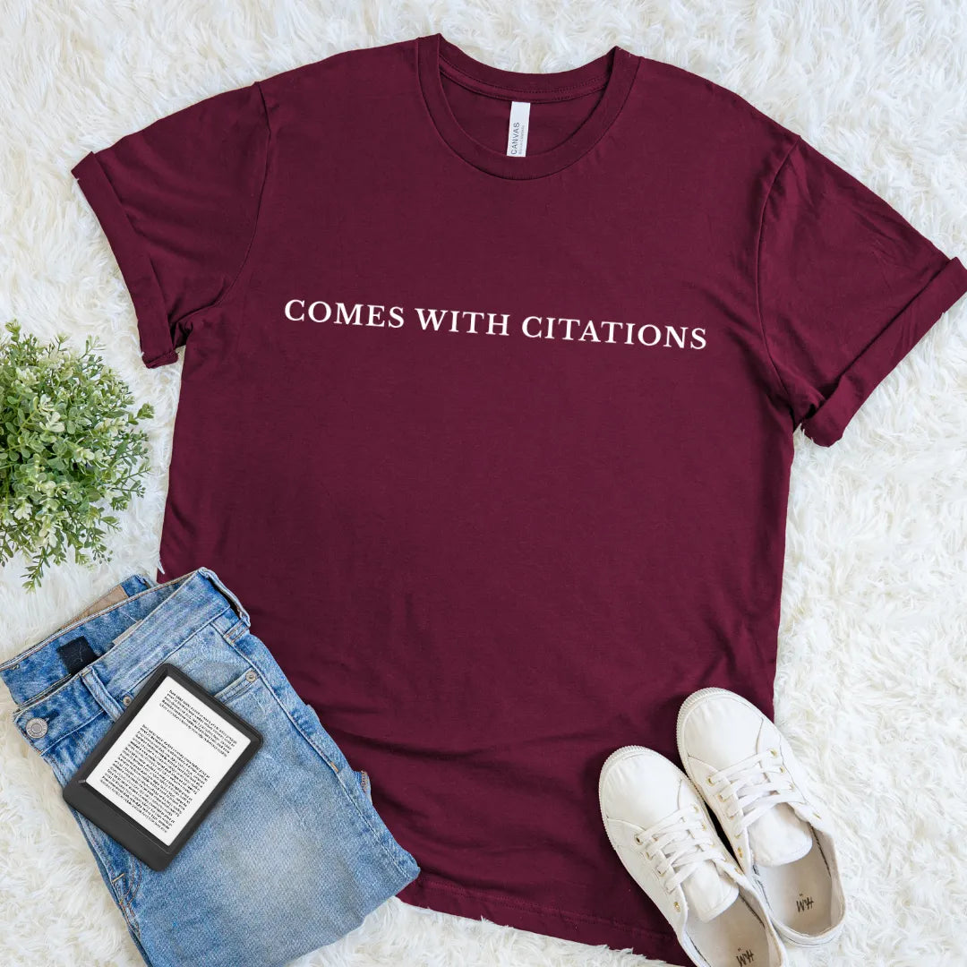 Maroon Comes With Citations bookish T-shirt with minimalist cream typography, a witty literary shirt for avid readers, librarians, academics, and fact-checkers.