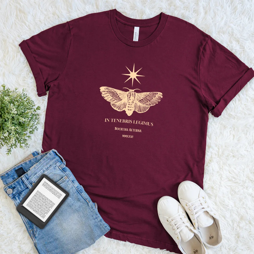 Minimal gold moth print and latin quote on maroon t-shirt for an understated, intellectual aesthetic.