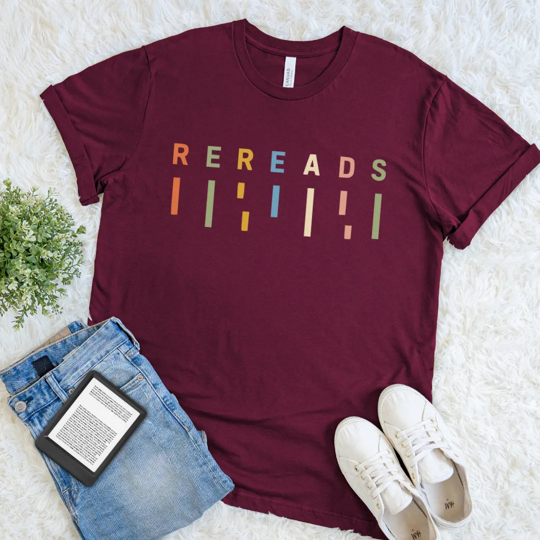 Maroon red reader shirt featuring colorful Rereads lettering with playful geometric book-inspired marks.