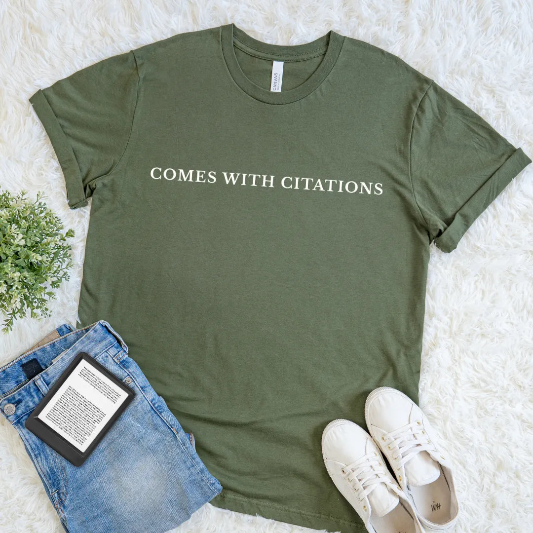 Military Green Comes With Citations bookish T-shirt with minimalist cream serif typography, a clever literary tee for readers, researchers, academics, and librarians.