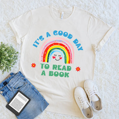 cream shirt with a rainbow and text design saying "It’s a good day to read a book"