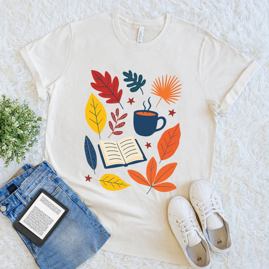 Graphic tee featuring open book, coffee mug, and leaves, seasonal gift for readers