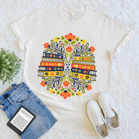 Decorative folk-style design featuring books and blooms on cream t-shirt