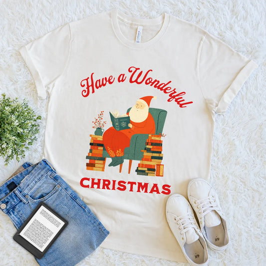 beige tee with holiday design featuring Santa and piles of colorful books