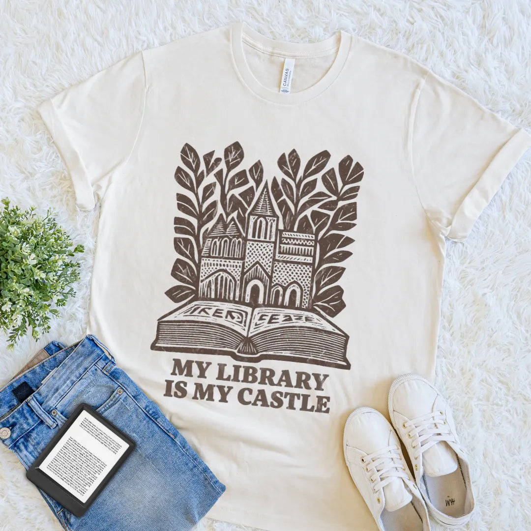 Vintage-style reader shirt featuring library castle artwork and botanical details on natural beige cotton