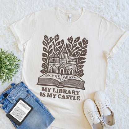 Vintage-style reader shirt featuring library castle artwork and botanical details on natural beige cotton