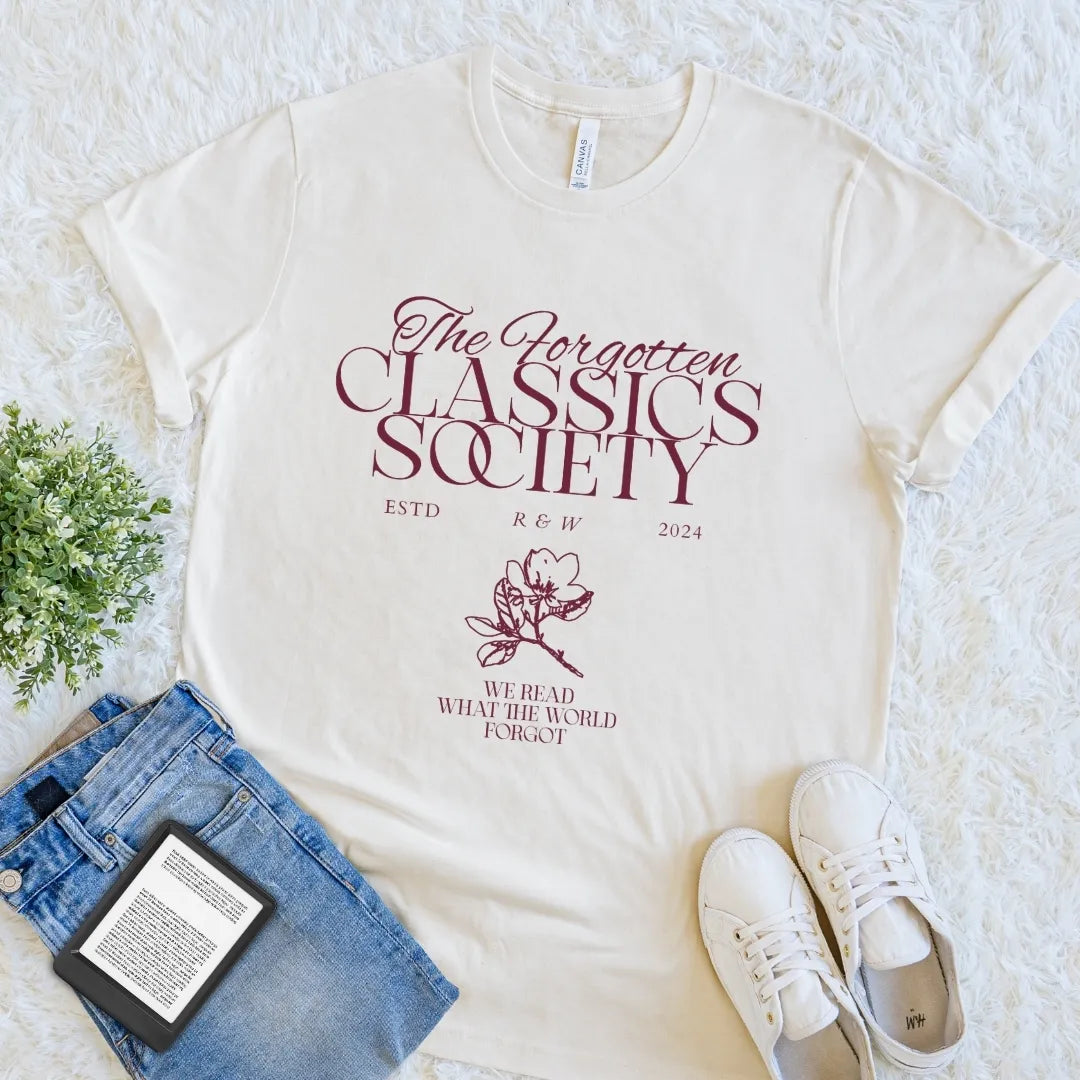 Natural Forgotten Classics Society bookish T-shirt featuring vintage serif lettering, subtle floral detail, and “We Read What the World Forgot,” a literary shirt for readers of overlooked classics.