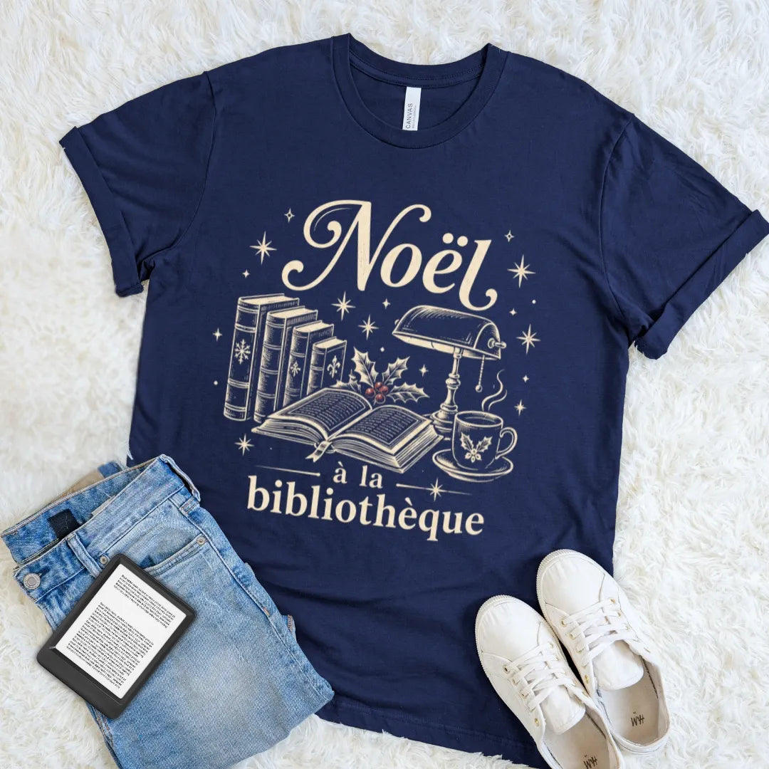 Navy Noël à la Bibliothèque T-shirt with antique books, a reading lamp, holly, and winter stars