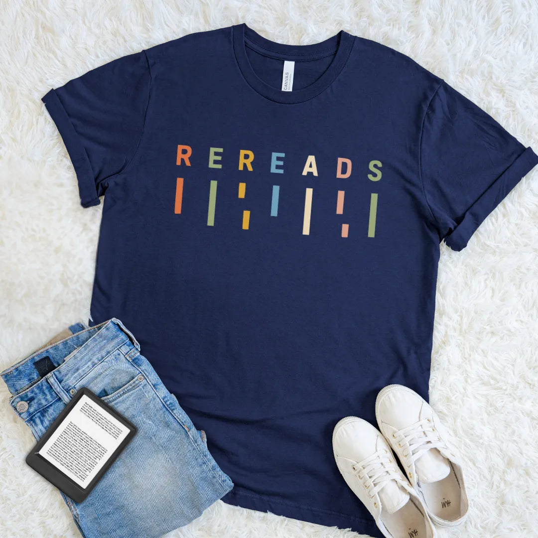 Navy literary T-shirt with colorful minimalist Rereads design styled with jeans, sneakers, and an e-reader.