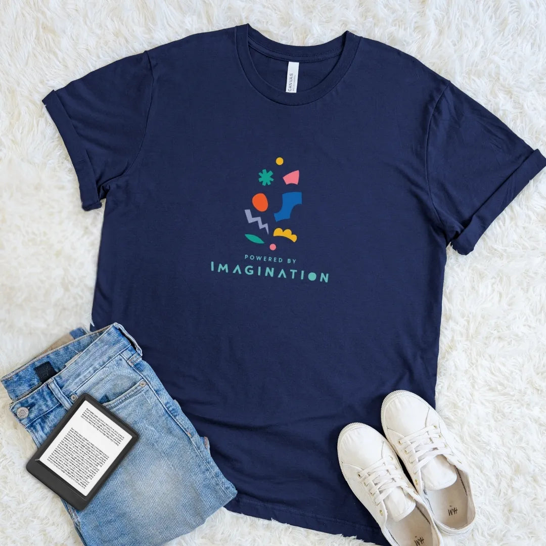 Navy Powered by Imagination literary T-shirt with vibrant multicolor shapes and bold playful text, a high-contrast bookish graphic tee for imaginative readers.