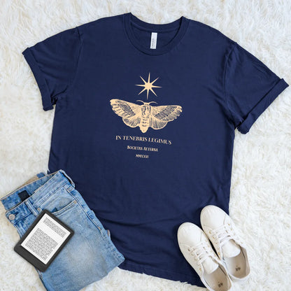 Soft cotton navy t-shirt featuring latin  quote "we read in dark" in golden typography  and vintage moth and stars design 