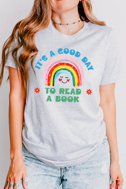 woman wearing soft cotton T-shirt featuring “It’s a good day to read a book” quote and happy rainbow
