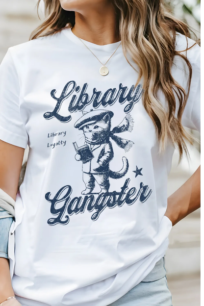 woman wearing white T-shirt with vintage cat in beret reading a book and "Librarty Gangster" quote