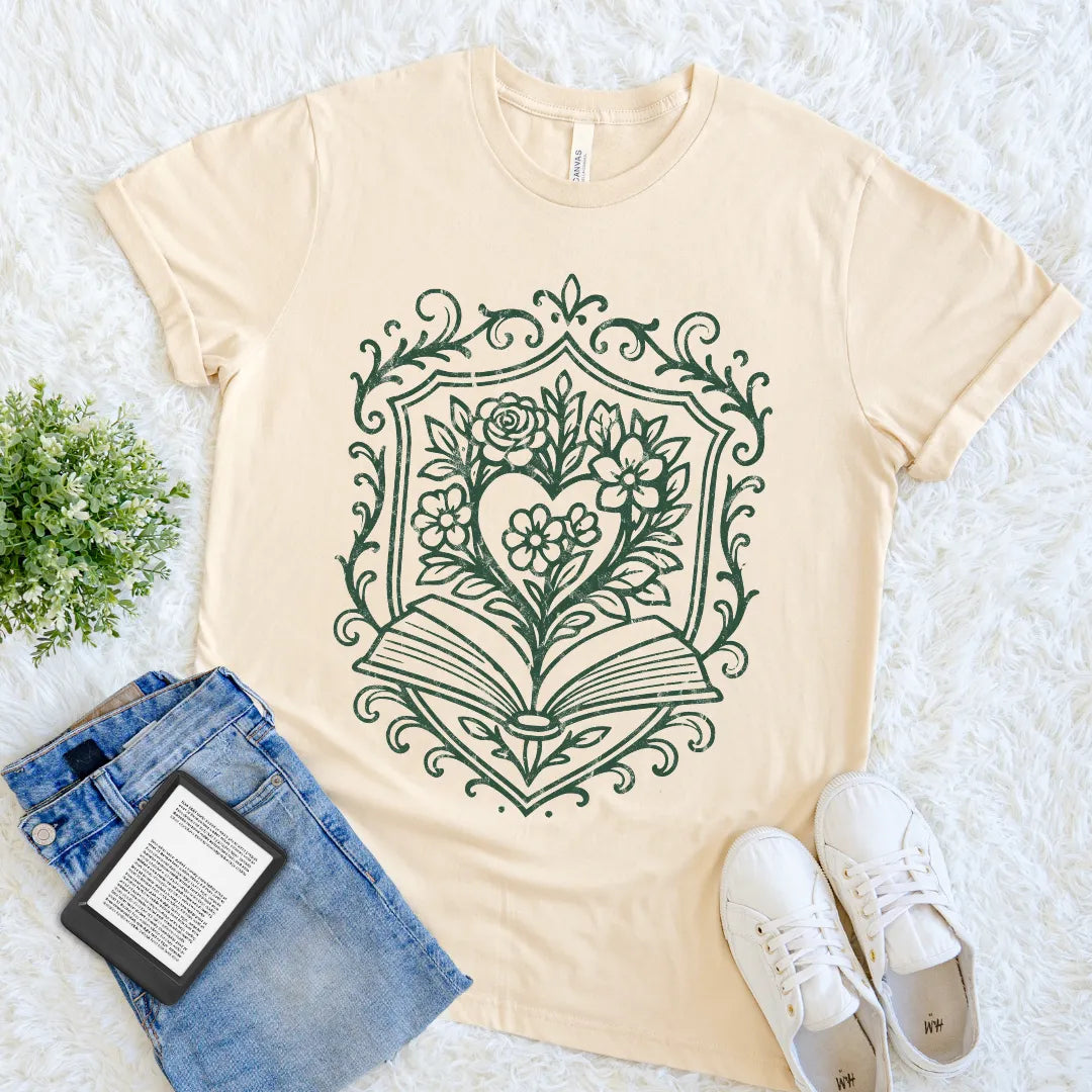 Soft cream book lover T-shirt with floral heart design growing from open book illustration