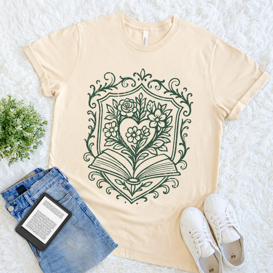 Soft cream book lover T-shirt with floral heart design growing from open book illustration