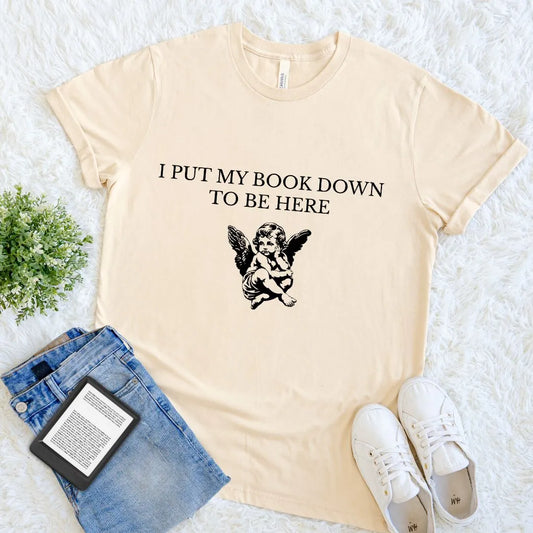 Soft Cream cotton book lover T-shirt with black cherub illustration and bold serif quote