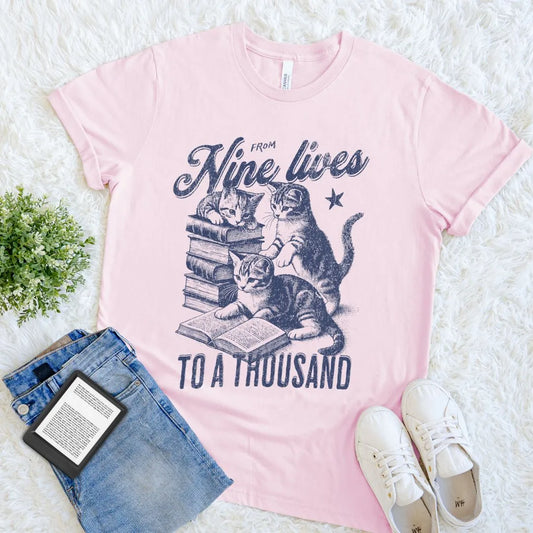 Literary shirt with whimsical text “From Nine Lives to a Thousand” and vintage books and kittens art in soft pink color