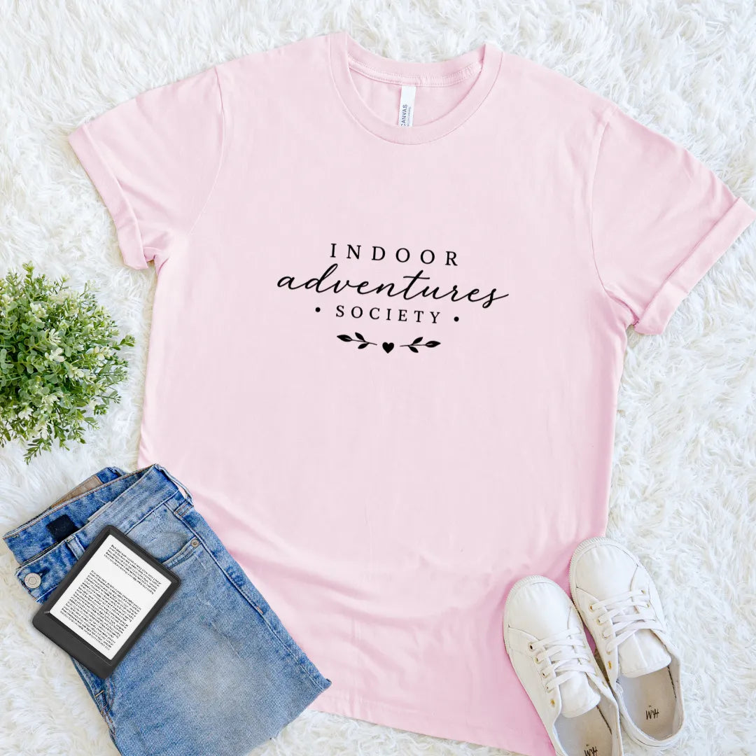 Soft pink bookish T-shirt with Indoor Adventures Society text design