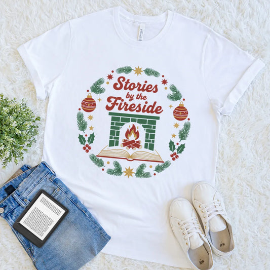 White bookish tee with a fireplace and open book surrounded by festive greenery