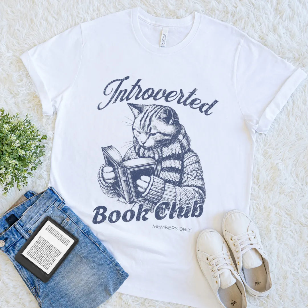 “Introverted Book Club” white t-shirt with cozy sweater cat reading book