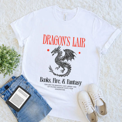 White soft cotton t-shirt with 'Dragon's Lair' graphic design on a white surface with jeans and sneakers.  