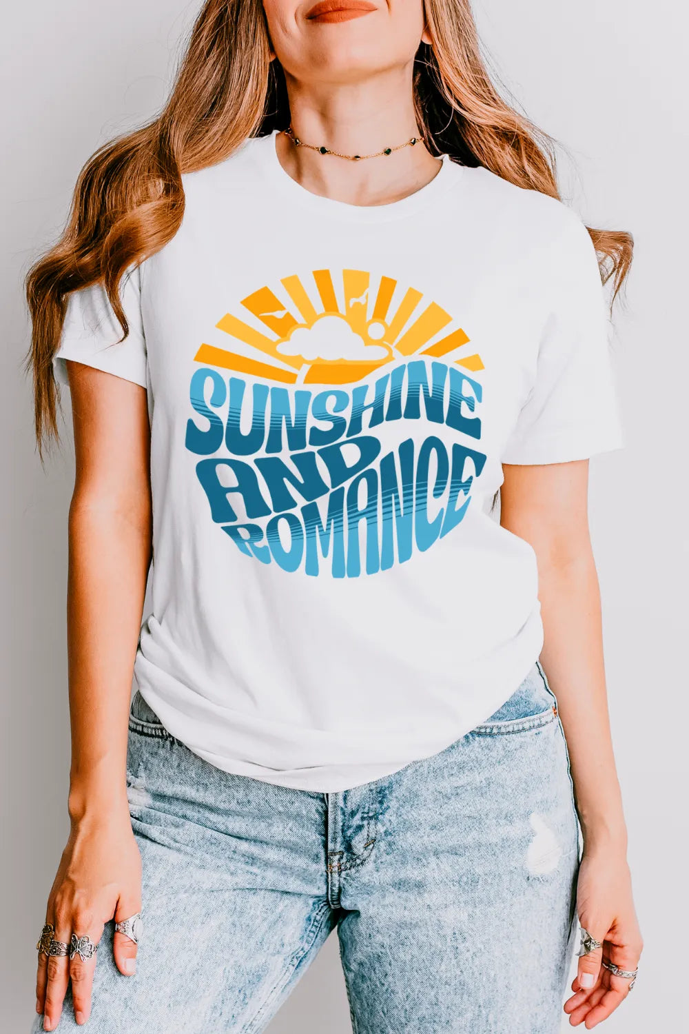woman wearing soft cotton  white T-shirt with retro “Sunshine and Romance” text in sun and sea design