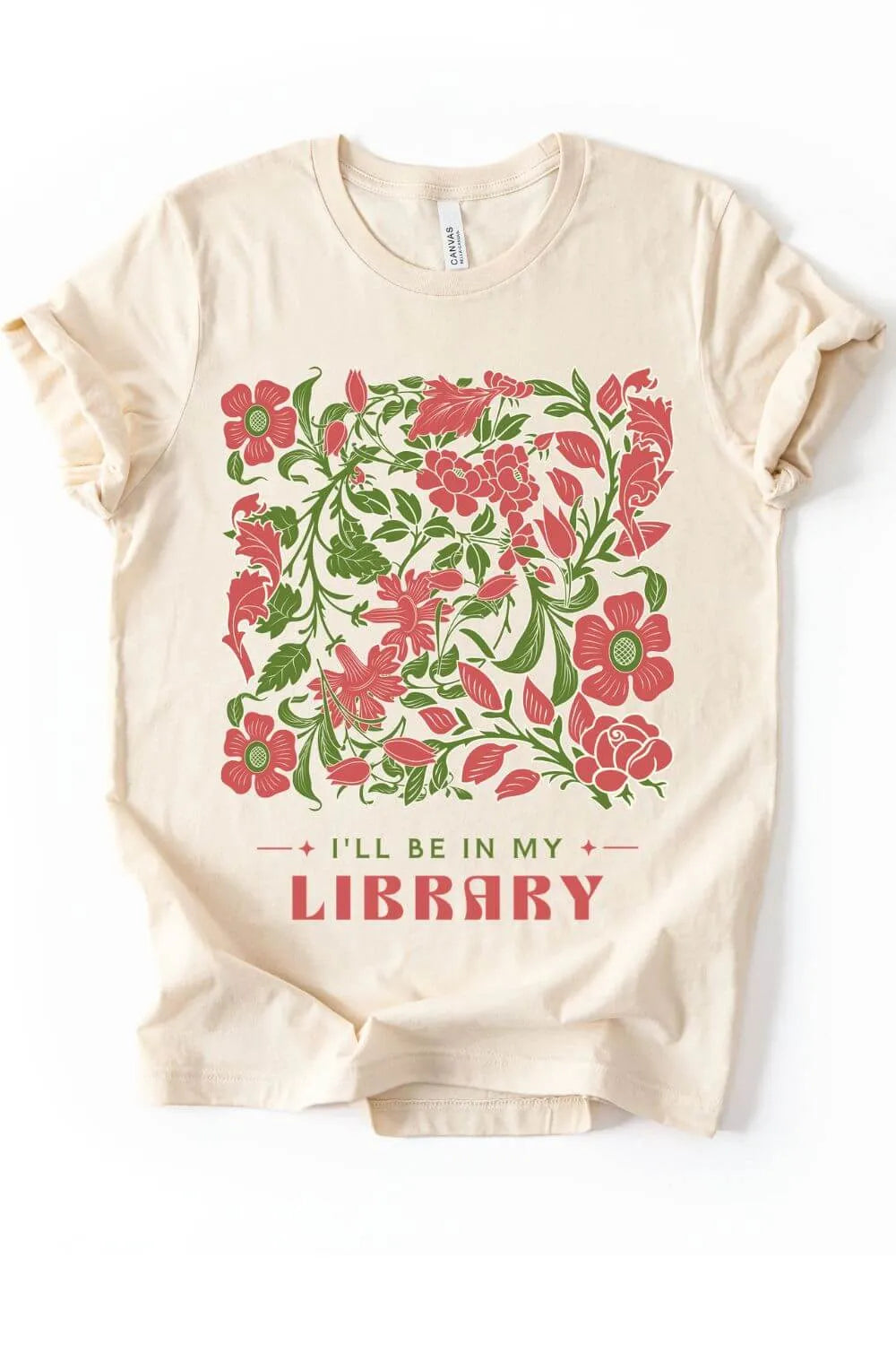 Soft cotton natural beige t-shirt featuring a red and green vintage floral illustration above the phrase “I’ll Be in My Library” in decorative lettering, styled in a cottagecore aesthetic.