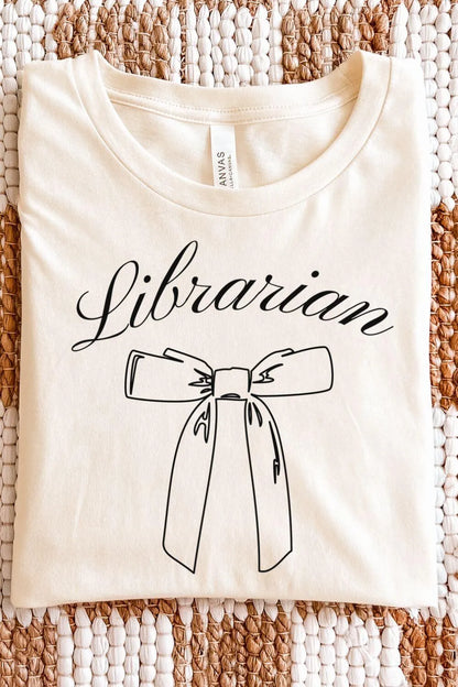 A cream-colored minimalist t-shirt with the word “Librarian” in elegant script and a simple bow illustration, styled in a light academia aesthetic