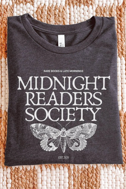 A soft dark heather gray t-shirt with vintage white text reading “Midnight Readers Society” and a detailed moth illustration, styled in a moody bookish aesthetic.