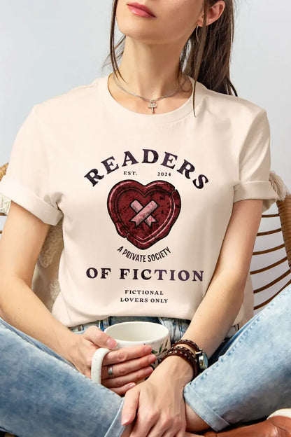 woman wearing a soft cotton cream bookish shirt featuring a “Readers of Fiction” quote with heart graphic and private society design